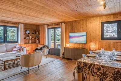a living room with a table and a tv at Appartement Périade - Welkeys in Megève
