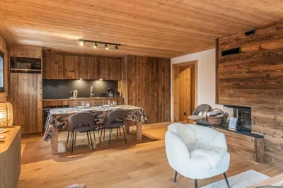 a dining room with wooden walls and a table and chairs at Appartement Périade - Welkeys in Megève