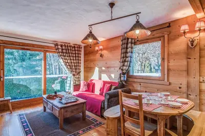 a living room with a table and a couch at Appartement des Epis - Welkeys in Megève