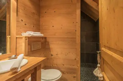 a bathroom with a toilet and a sink and a tub at Appartement des Epis - Welkeys in Megève