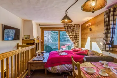 a bedroom with a bed and a table at Appartement des Epis - Welkeys in Megève