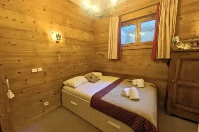 a bedroom with a bed in a log cabin at Appartement des Epis - Welkeys in Megève