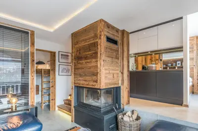 a living room with a fireplace and a kitchen at Appartement Perchets - Welkeys in Megève
