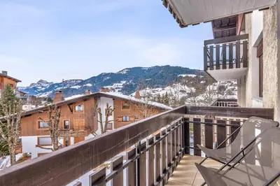 a balcony with chairs and a view of mountains at Appartement Perchets - Welkeys in Megève