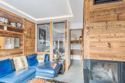 a living room with a blue couch and a fireplace at Appartement Perchets - Welkeys in Megève