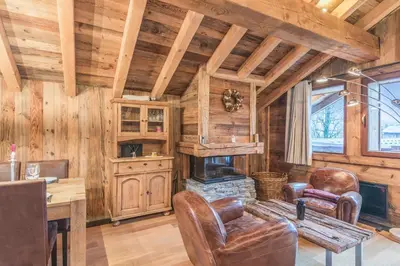 a living room with a fireplace in a log cabin at Chalet du Jaillet - Welkeys in Megève