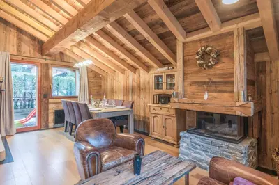 a living room with a fireplace in a log cabin at Chalet du Jaillet - Welkeys in Megève