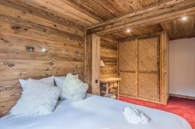 a bedroom with a bed in a wooden room at Chalet du Jaillet - Welkeys in Megève