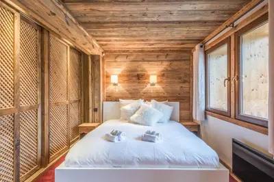 a bedroom with a bed in a room with wooden walls at Chalet du Jaillet - Welkeys in Megève