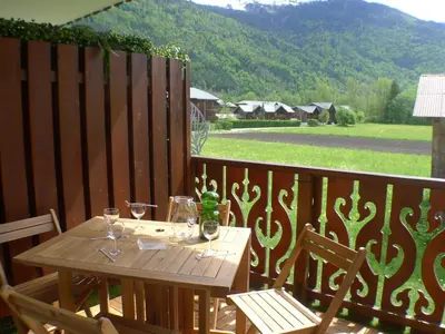 a wooden table with wine glasses on a balcony at Appartement 2 pièces avec balcon à Samoëns, parking inclus - FR-1-629-121 in Samoëns