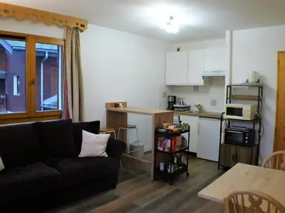 a living room with a couch and a kitchen at Appartement 2 pièces avec balcon à Samoëns, parking inclus - FR-1-629-121 in Samoëns