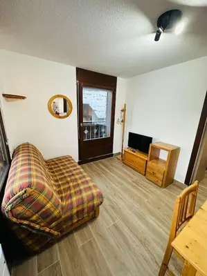 a living room with a couch and a table at Studio Hyper centre in Les Carroz d'Araches