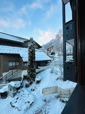 a snow covered yard with a building and a house at Studio Hyper centre in Les Carroz d'Araches