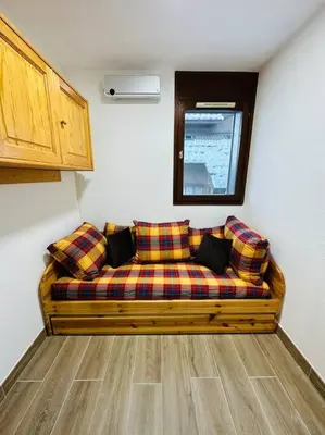 a couch in the corner of a room at Studio Hyper centre in Les Carroz d'Araches