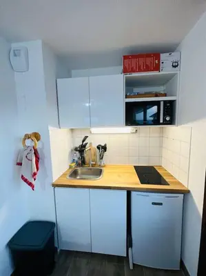 a small kitchen with white cabinets and a sink at Studio Hyper centre in Les Carroz d'Araches