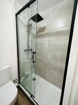 a glass shower in a bathroom with a toilet at Studio Hyper centre in Les Carroz d'Araches