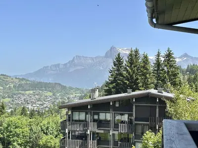 a house on a hill with mountains in the background at Appartement 3 pièces + cabine à Megève, 6 couchages, proche pistes et téléphérique - FR-1-597-170 in Megève