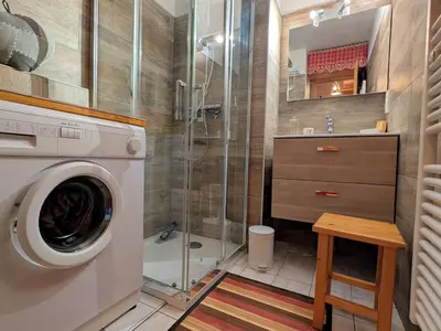 a bathroom with a shower and a washing machine at Charmant T2 proche du centre avec parking - FR-1-624-127 in Samoëns