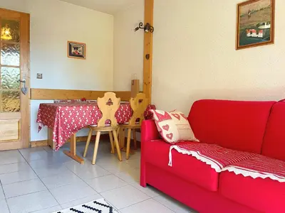 a living room with a red couch and a table at Charmant T2 proche du centre avec parking - FR-1-624-127 in Samoëns
