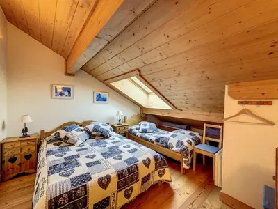 two beds in a room with a wooden ceiling at Bells Lodge in Chamonix-Mont-Blanc