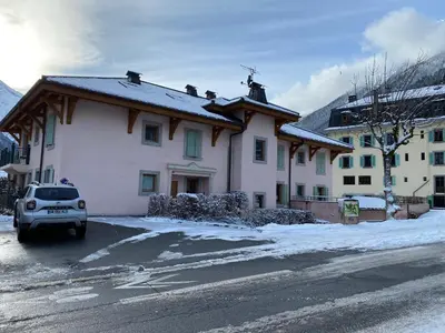 a house with a car parked in a parking lot at Bells Lodge in Chamonix-Mont-Blanc