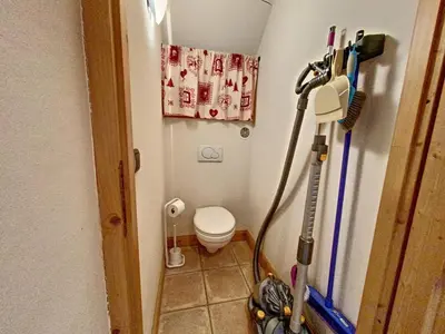 a small bathroom with a toilet and a vacuum at Bells Lodge in Chamonix-Mont-Blanc