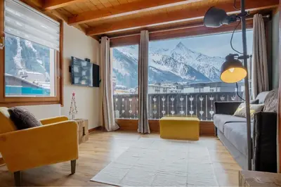 a living room with a large window with a mountain view at Refuge de l'Aiguille - 2 bedroom duplex in the heart of Chamonix in Chamonix-Mont-Blanc