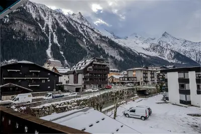 a town with snow covered buildings and a mountain at Refuge de l'Aiguille - 2 bedroom duplex in the heart of Chamonix in Chamonix-Mont-Blanc