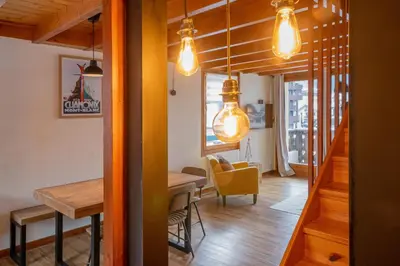 a dining room with a table and some lights at Refuge de l'Aiguille - 2 bedroom duplex in the heart of Chamonix in Chamonix-Mont-Blanc