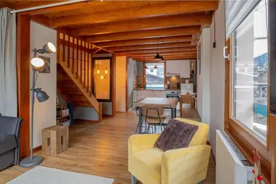 a living room with a yellow chair and a table at Refuge de l'Aiguille - 2 bedroom duplex in the heart of Chamonix in Chamonix-Mont-Blanc