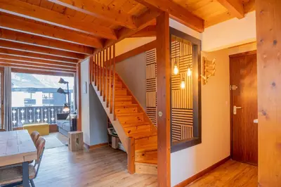 a wooden staircase in a living room with a table at Refuge de l'Aiguille - 2 bedroom duplex in the heart of Chamonix in Chamonix-Mont-Blanc