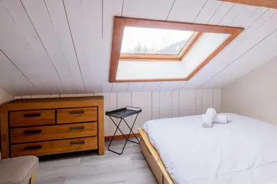 a attic bedroom with a bed and a window at Refuge de l'Aiguille - 2 bedroom duplex in the heart of Chamonix in Chamonix-Mont-Blanc