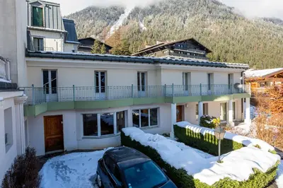 a house with a car parked in the snow at Miremont Apartment - Chamonix All Year in Chamonix-Mont-Blanc