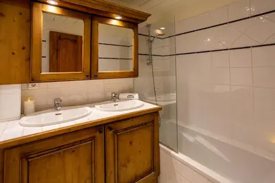 a bathroom with two sinks and a mirror and a tub at Miremont Apartment - Chamonix All Year in Chamonix-Mont-Blanc