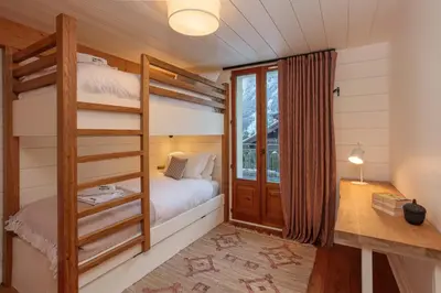 a bedroom with two bunk beds and a window at Miremont Apartment - Chamonix All Year in Chamonix-Mont-Blanc