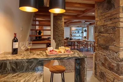 a kitchen with a table with a bottle of wine and glasses at Miremont Apartment - Chamonix All Year in Chamonix-Mont-Blanc