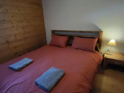 a bedroom with a bed with two pillows on it at Ecrins A4, 1 bedroom apartment with bunk room, central Samoëns in Samoëns