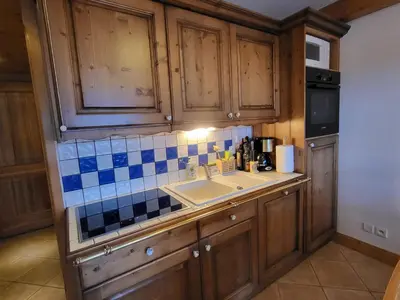 a kitchen with wooden cabinets and a sink at Ecrins A4, 1 bedroom apartment with bunk room, central Samoëns in Samoëns
