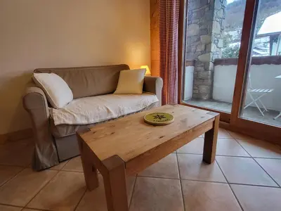 a living room with a couch and a coffee table at Ecrins A4, 1 bedroom apartment with bunk room, central Samoëns in Samoëns
