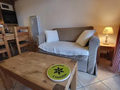 a living room with a couch and a table at Ecrins A4, 1 bedroom apartment with bunk room, central Samoëns in Samoëns
