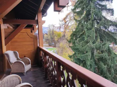 a porch with two chairs and a christmas tree at Spacieux T3, 6 pers, calme, balcon, parking, casier à skis, navette à 150m - FR-1-572-278 in Arâches-la-Frasse