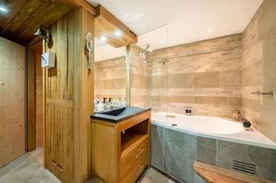 a bathroom with a tub and a sink at Chalet Ananda avec Sauna, Baignoire Balnéo et Terrasse in Chamonix-Mont-Blanc