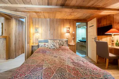 a bedroom with a bed in a room with wooden walls at Chalet Ananda avec Sauna, Baignoire Balnéo et Terrasse in Chamonix-Mont-Blanc