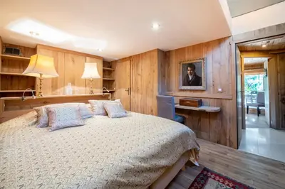a bedroom with a large bed with wooden walls at Chalet Ananda avec Sauna, Baignoire Balnéo et Terrasse in Chamonix-Mont-Blanc