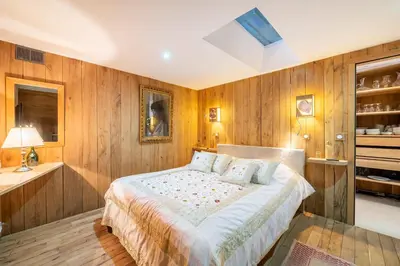 a bedroom with wooden walls and a bed with pillows at Chalet Ananda avec Sauna, Baignoire Balnéo et Terrasse in Chamonix-Mont-Blanc
