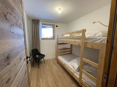 a bedroom with two bunk beds and a chair at Appartement 5 pièces au pied des pistes, 8 pers, avec parking et WiFi - FR-1-572-277 in Arâches-la-Frasse
