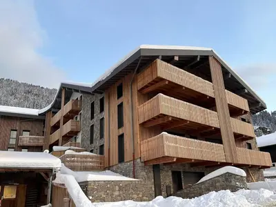 a building with wooden balconies in the snow at Appartement 5 pièces au pied des pistes, 8 pers, avec parking et WiFi - FR-1-572-277 in Arâches-la-Frasse