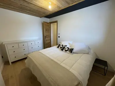 a bedroom with a white bed with a wooden ceiling at Appartement 5 pièces au pied des pistes, 8 pers, avec parking et WiFi - FR-1-572-277 in Arâches-la-Frasse