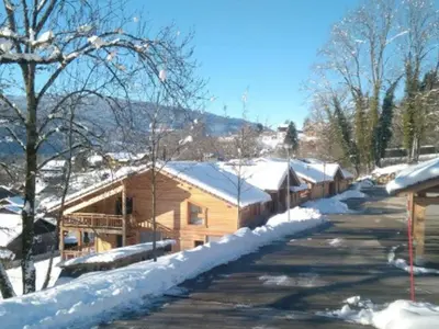 a log cabin in the snow with a road at Appartement lumineux T3 pour 4-6 pers avec WIFI et parking à Samoëns - FR-1-624-128 in Samoëns
