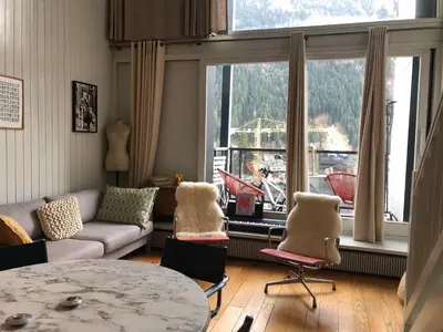 a living room with a couch and chairs and a large window at Design loft in Chamonix Center in Chamonix-Mont-Blanc